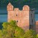 La cima del castillo de Urquhart se asoma entre las copas de los árboles al borde del lago
